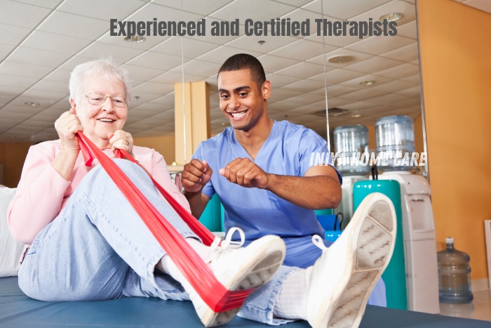 Experienced and certified therapist assisting an elderly woman with resistance band exercises, highlighting the professional physiotherapy services offered by Iniya Home Care in Pollachi. Ensuring expert care and personalized rehabilitation for enhanced recovery