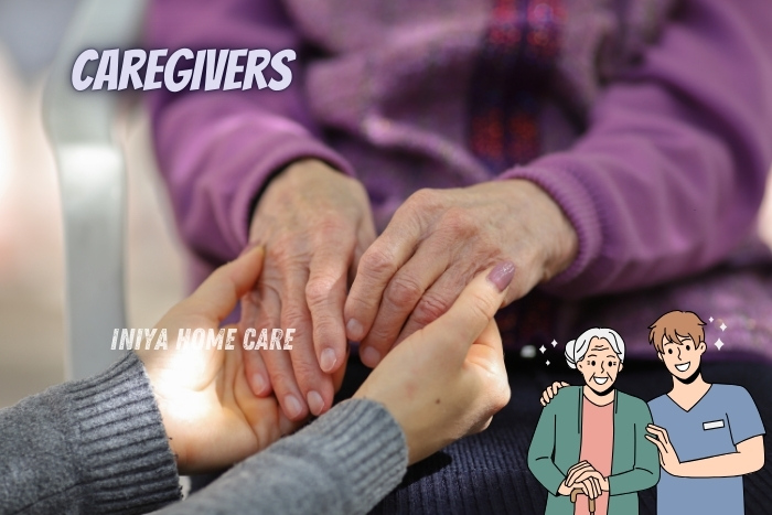 Caregivers from Iniya Home Care gently holding the hands of an elderly client, symbolizing compassion and support